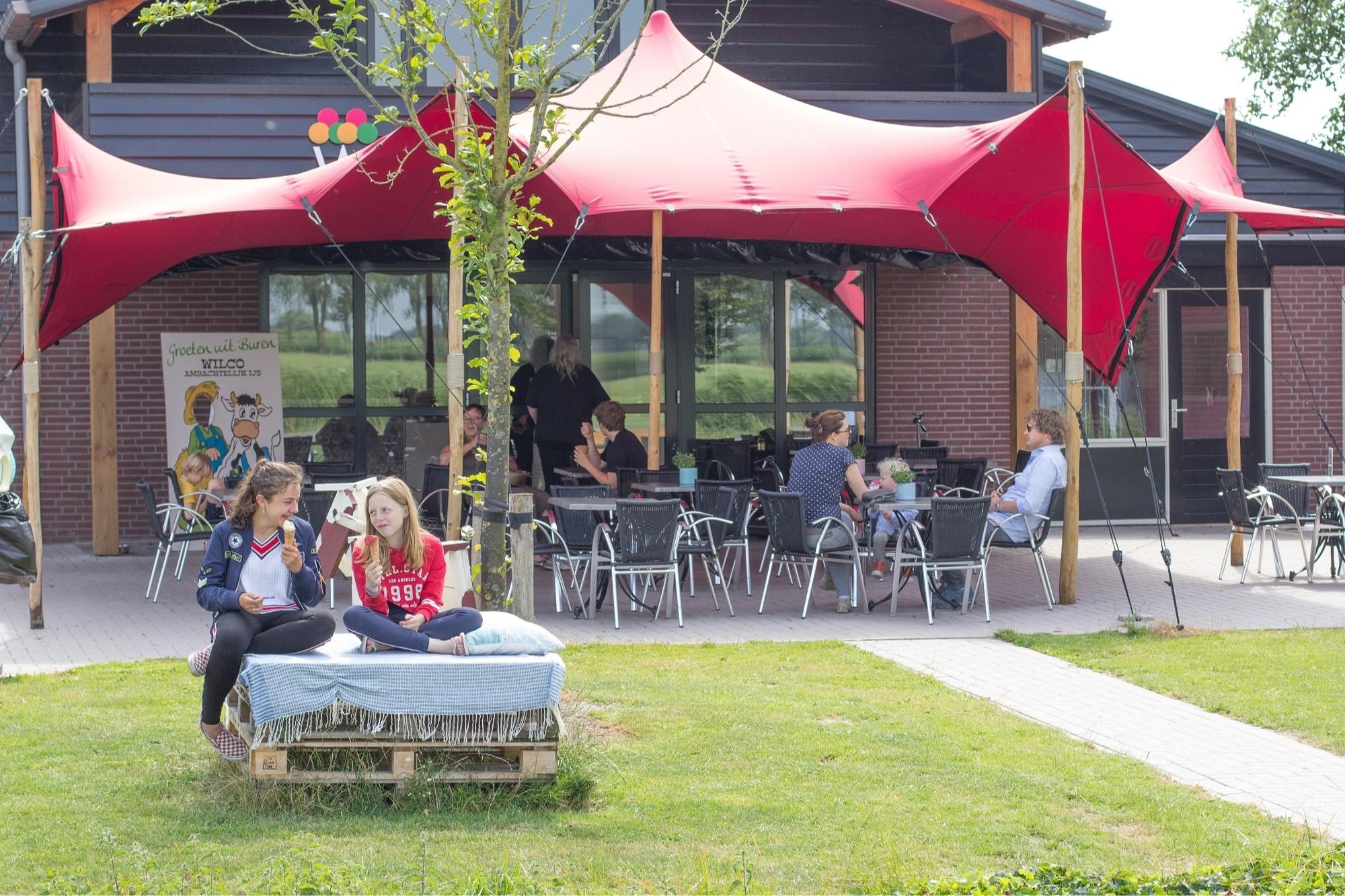 Kinderen eten een lekker ijsje op het terras bij Wilco AMbachtelijk Ijs in Buren